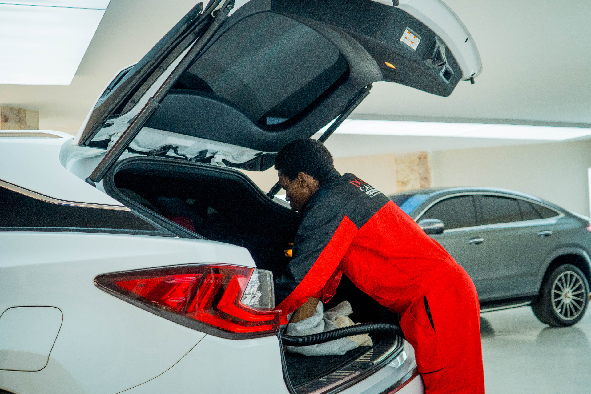 Donga technician vacuuming the rear cargo of a Lexus RX