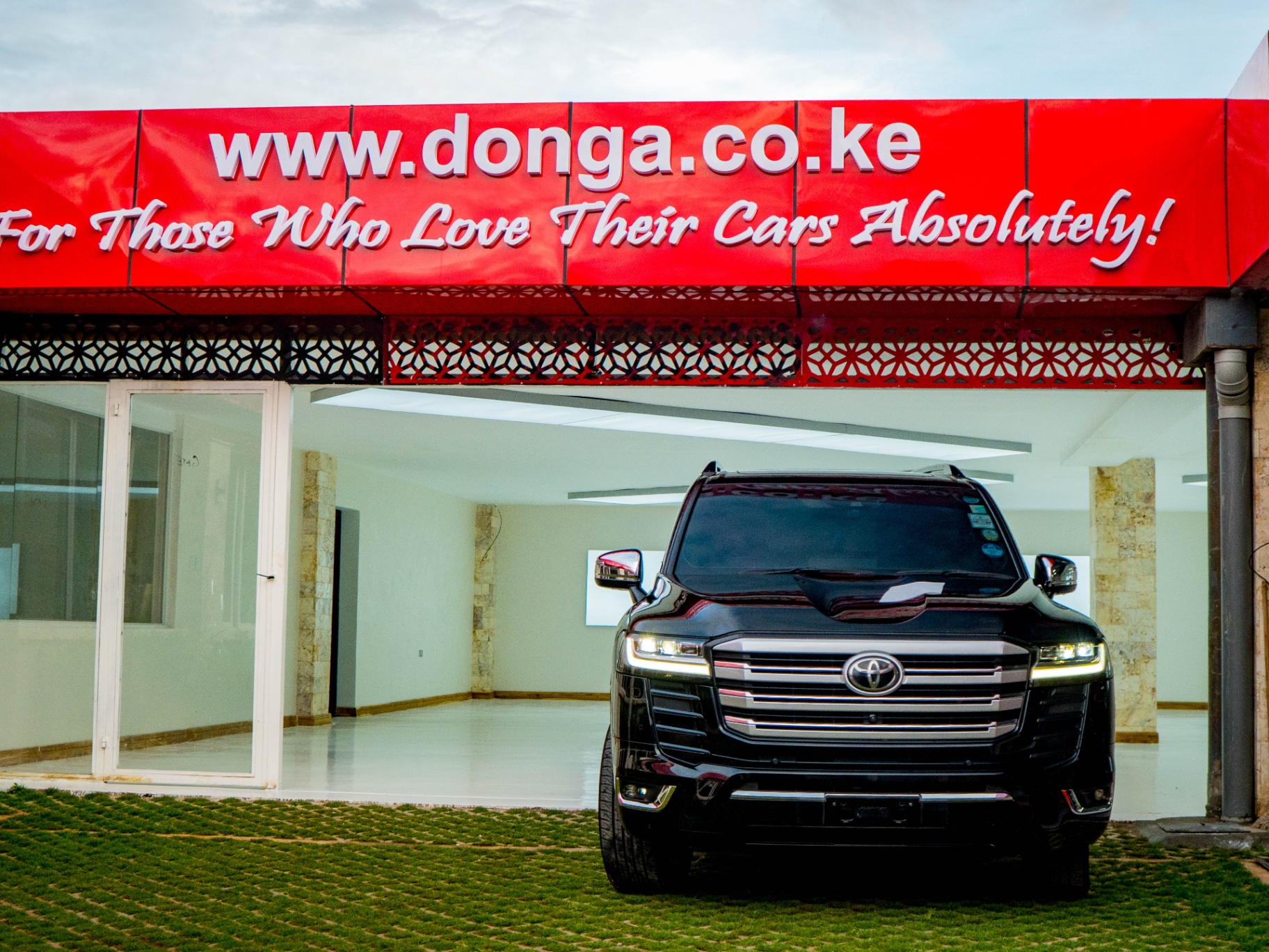 Black Toyota Land Cruiser 300 — front-on at Donga showroom entrance